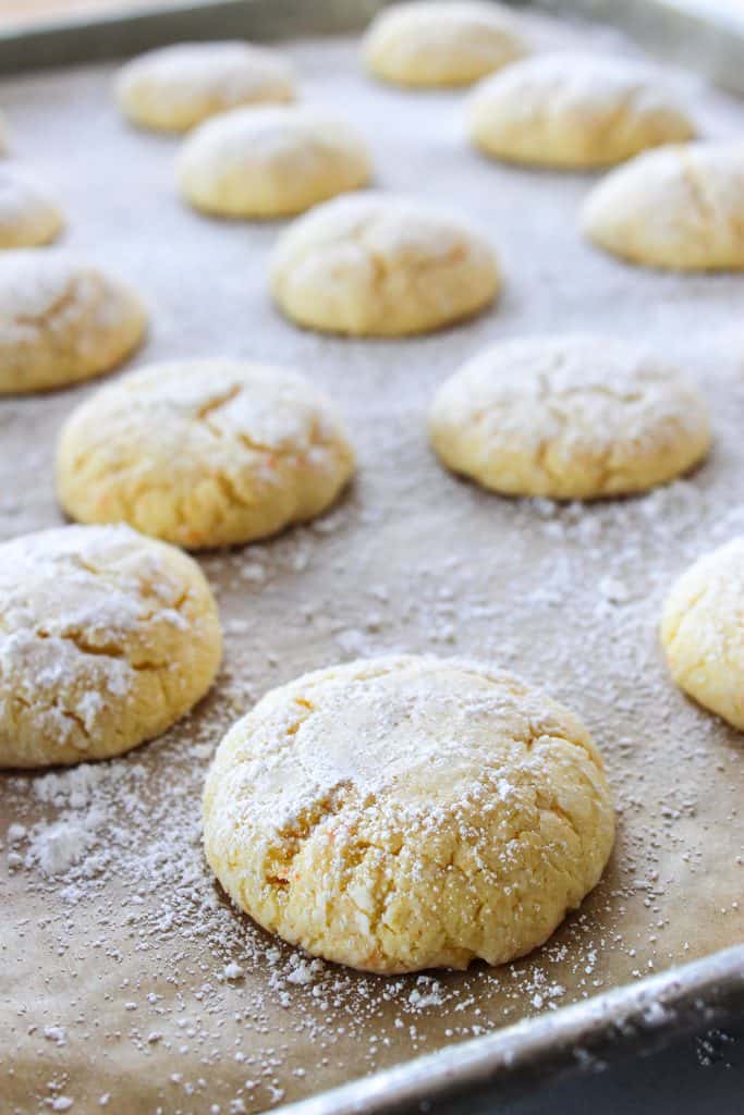 finished gooey butter cake cookies on a baking sheet sprinkled with powdered sugar