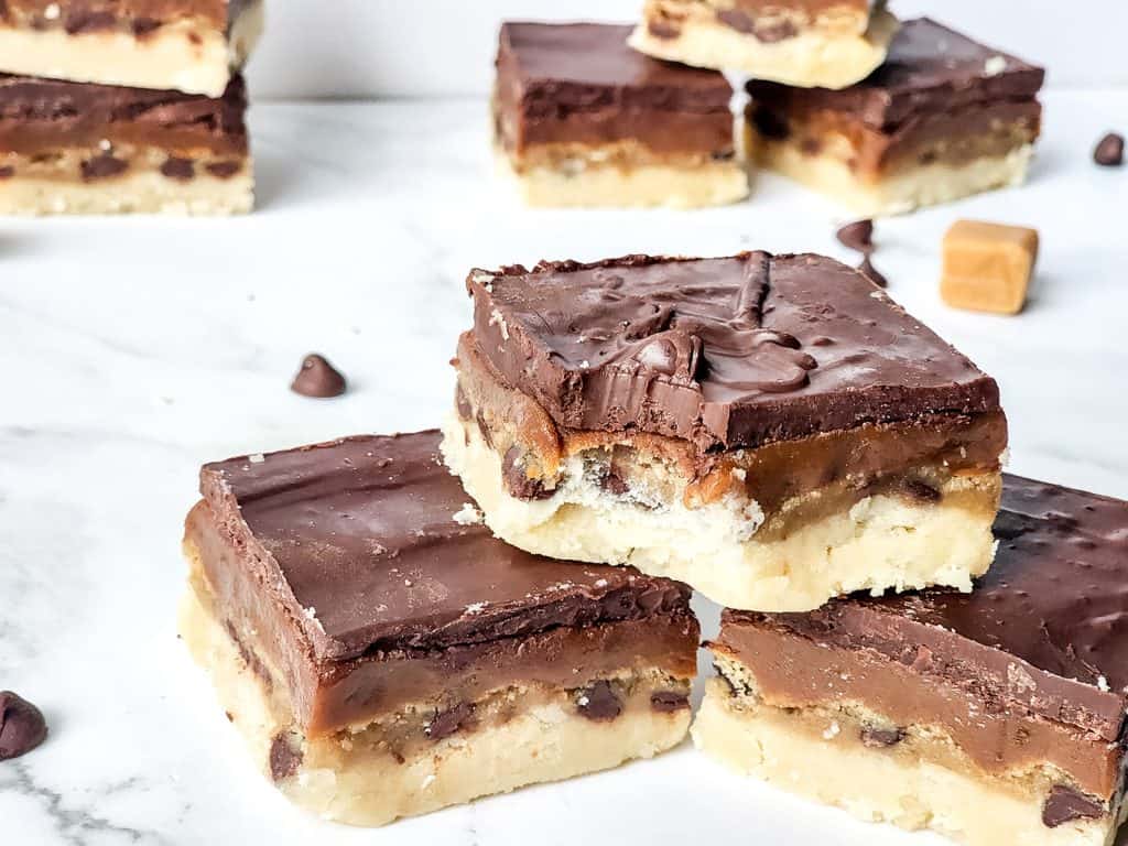 stack of finished twix cookie dough bars on marble counter