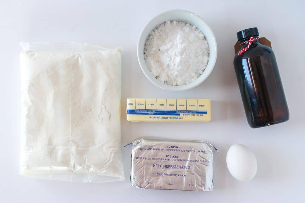 ingredients for gooey butter cake cookies: cake mix, powdered sugar, butter, cream cheese, egg, and vanilla extract