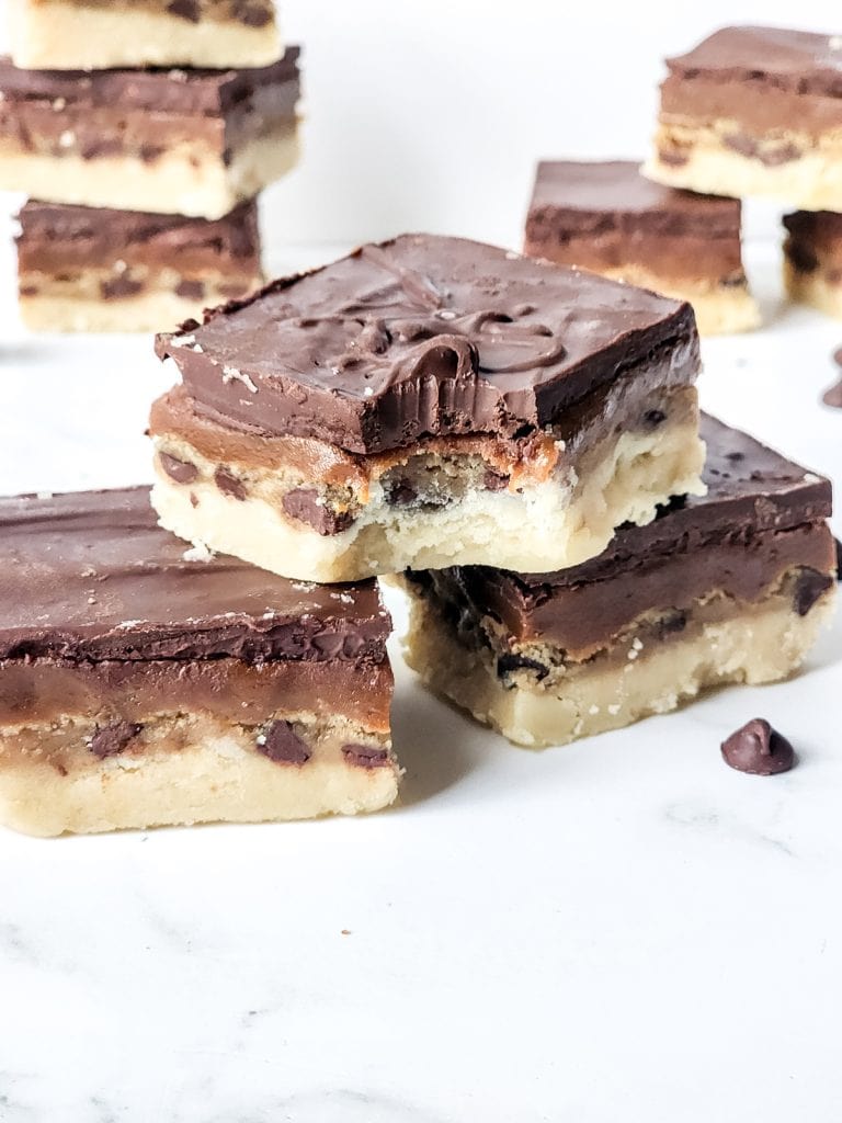 stack of finished and cut twix cookie dough bars on marble counter