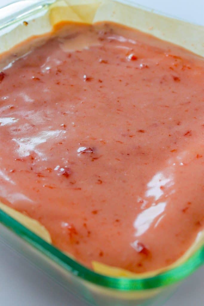 strawberry brownies in baking dish after being glazed