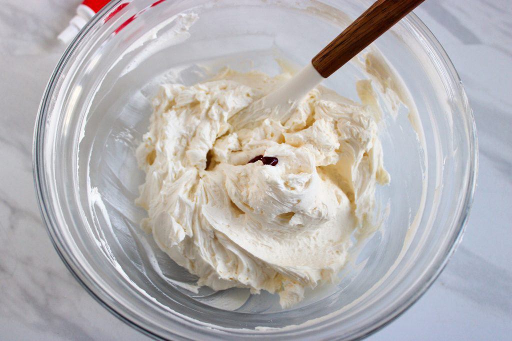 adding red food coloring to the buttercream mixture