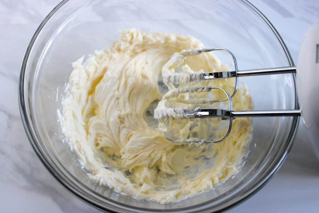 using a mixer to cream butter in a bowl