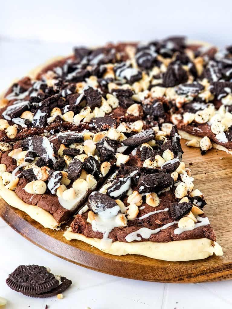 close up of oreo dessert pizza cut into slices