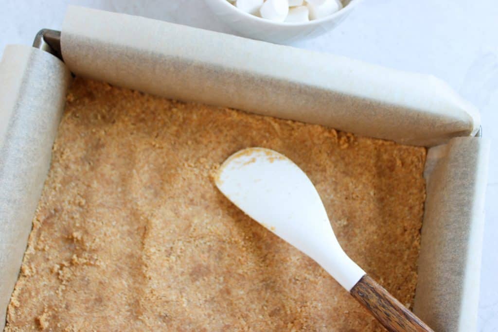 graham cracker layer in parchment paper lined dish