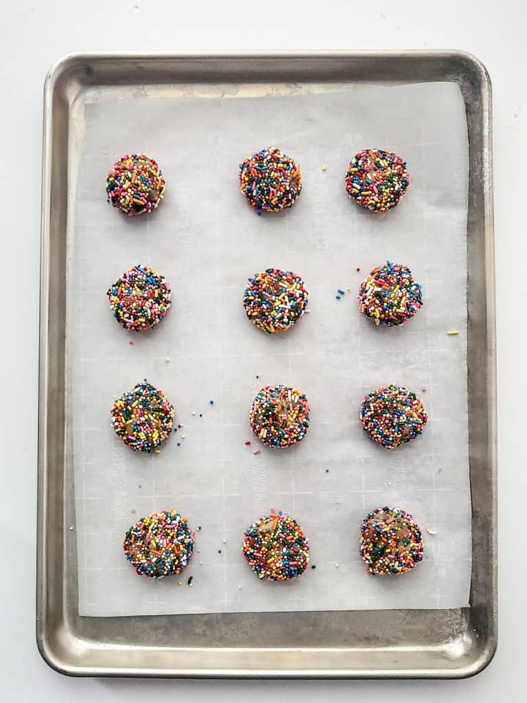 cookie dough balls with sprinkles on baking sheet