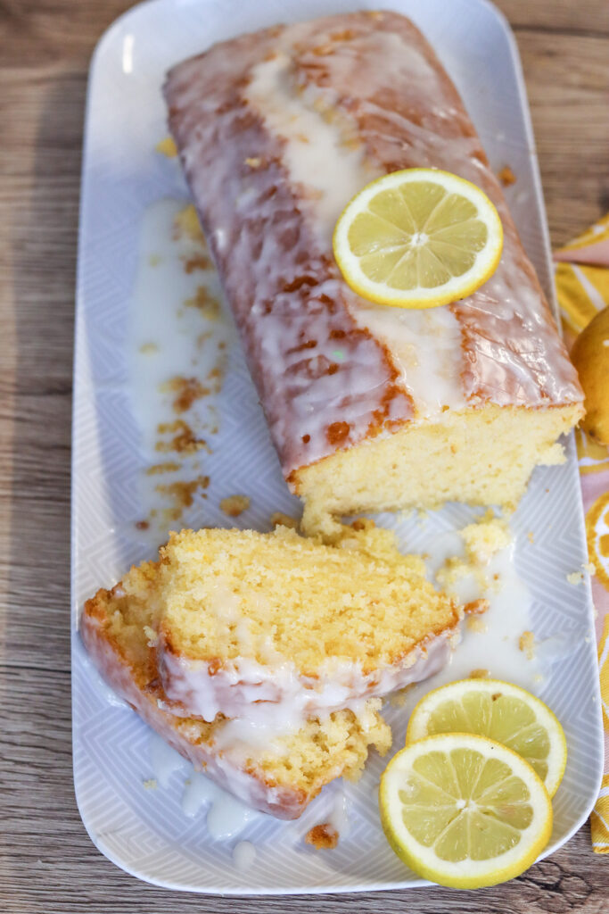 lemon cake on a plate with sliced lemons