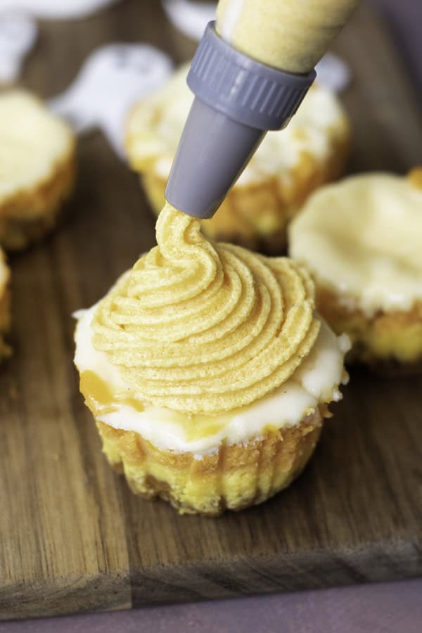 applying frosting to the cheesecakes