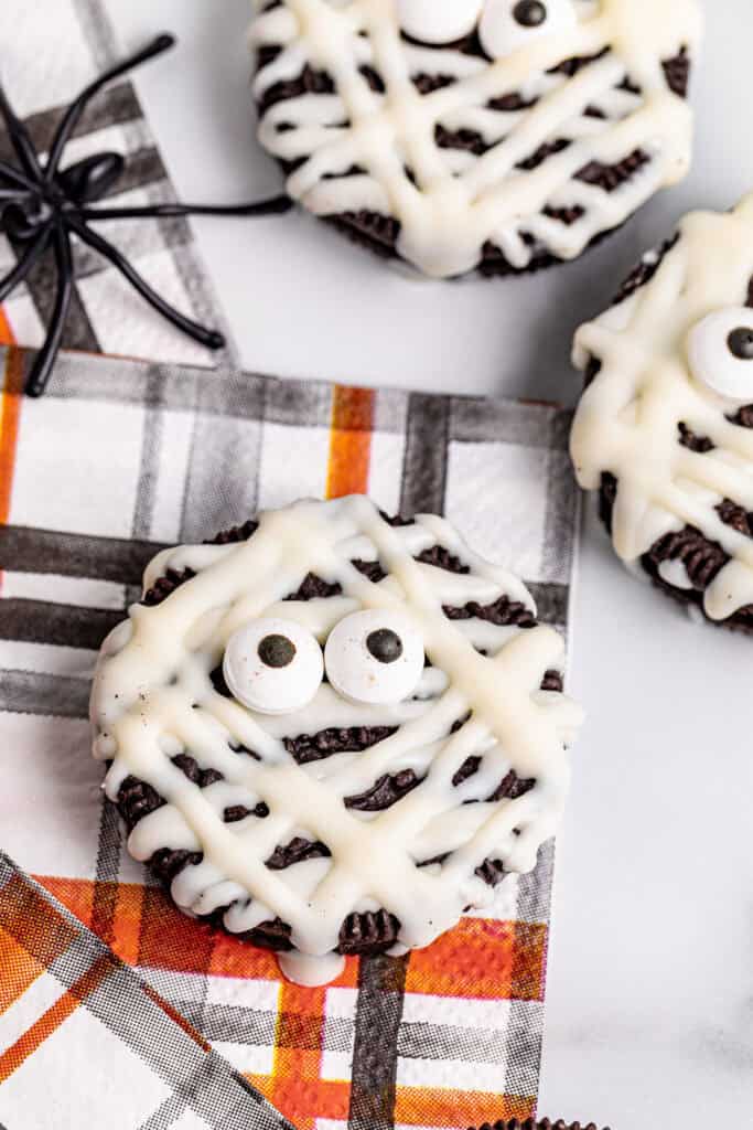 closeup of mummy Oreos on an orange and black plaid napkin