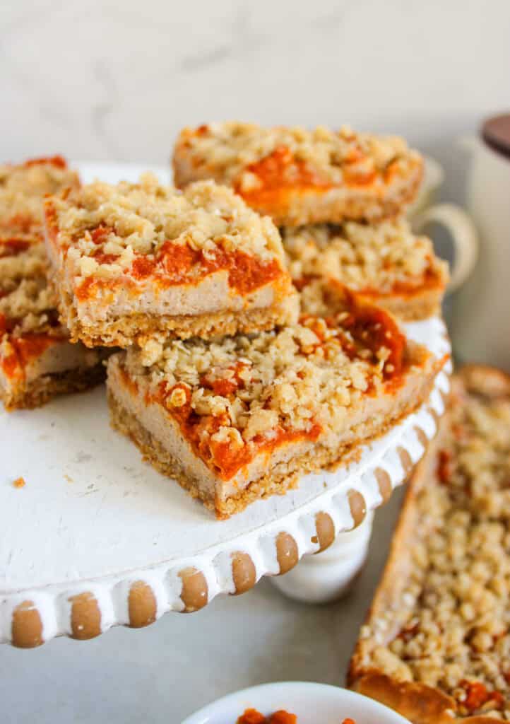 closeup of cream cheese pumpkin swirl bars on a cake stand