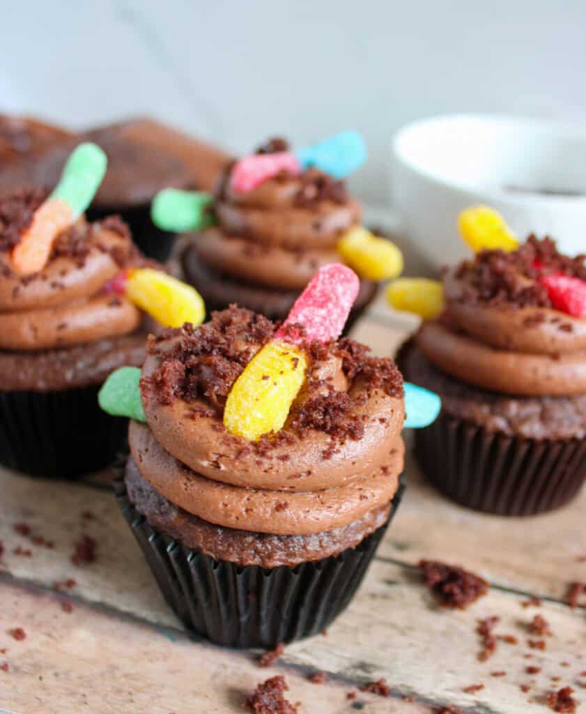 finished dirt cupcakes with gummy worms on countertop