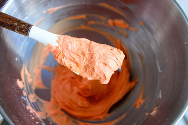 orange buttercream frosting on a spoon