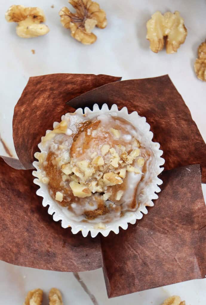 closeup of pumpkin muffins with powdered sugar icing and walnuts