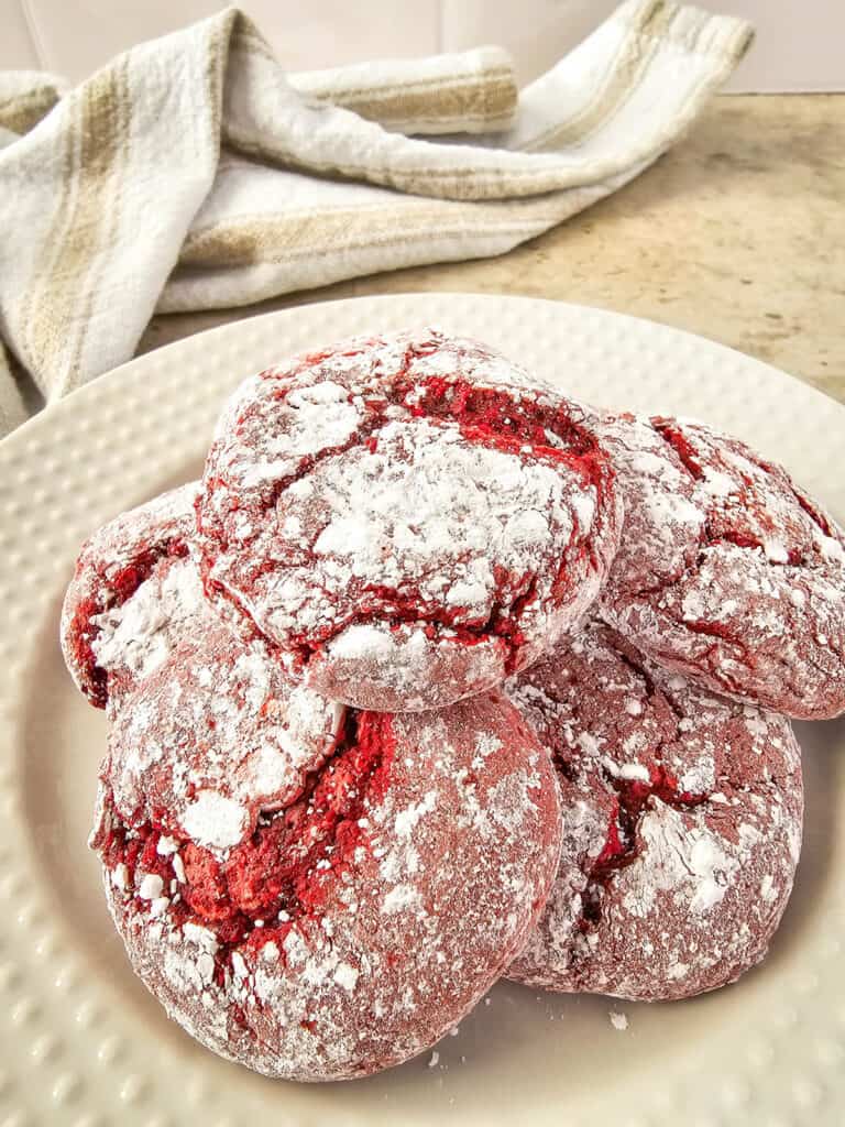 stack of red velvet crinkle cookies on a plate