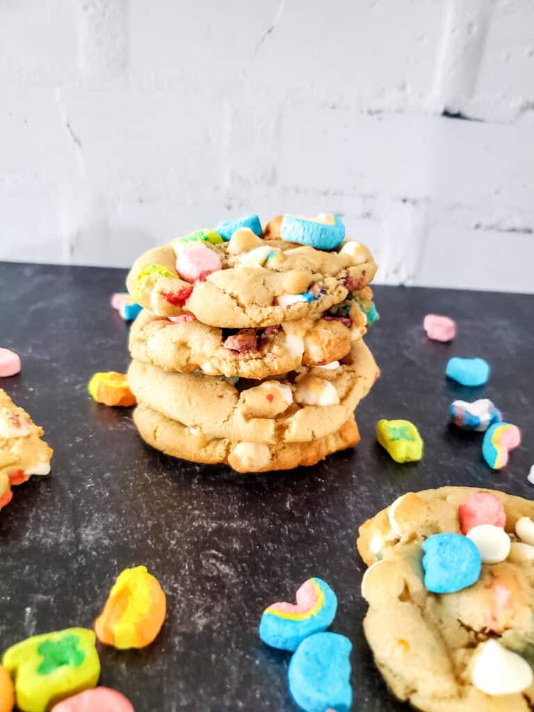 stack of lucky charms cookies on a counter surrounded by marshmallows