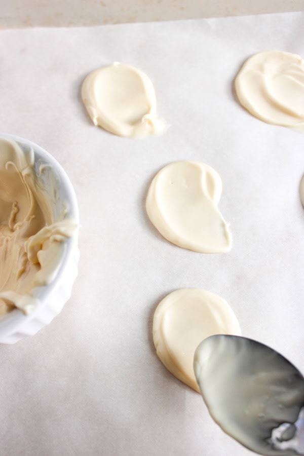 white chocolate swooped onto parchment paper to form ghost shapes