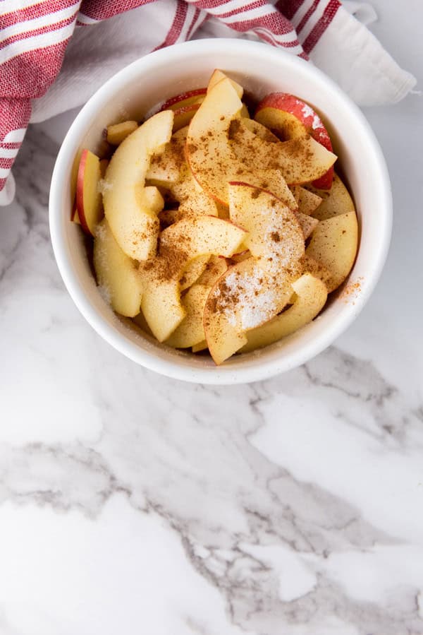 lemon, cinnamon, and sugar added to bowl of apple slices