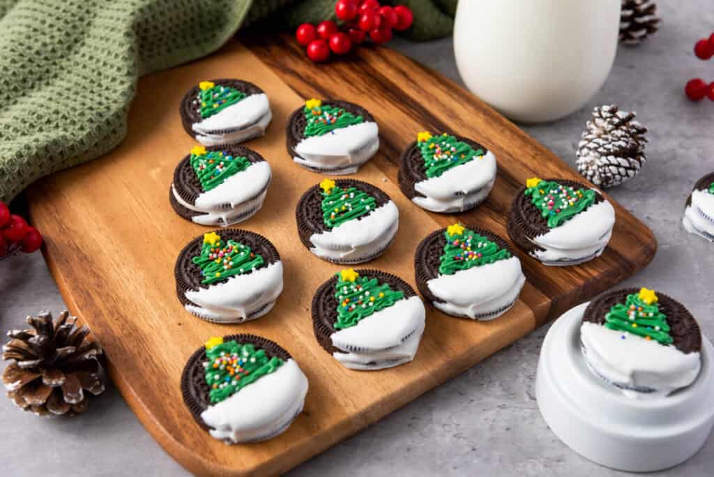 closeup of finished Oreos decorated with christmas trees on a counter