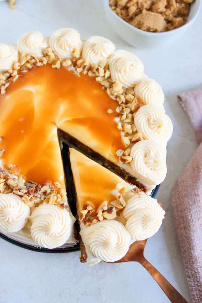 slicing the salted caramel cream cheese pumpkin cake