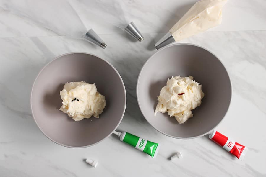 adding the food coloring to bowls of frosting