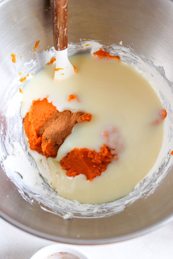 adding pumpkin and spices to cream cheese mixture