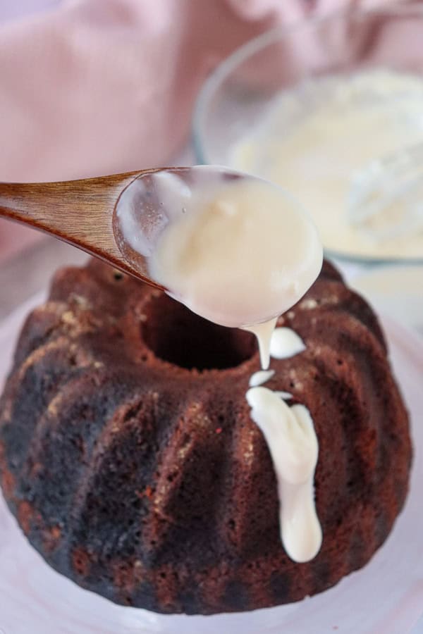 pouring frosting over cooled bundt cake