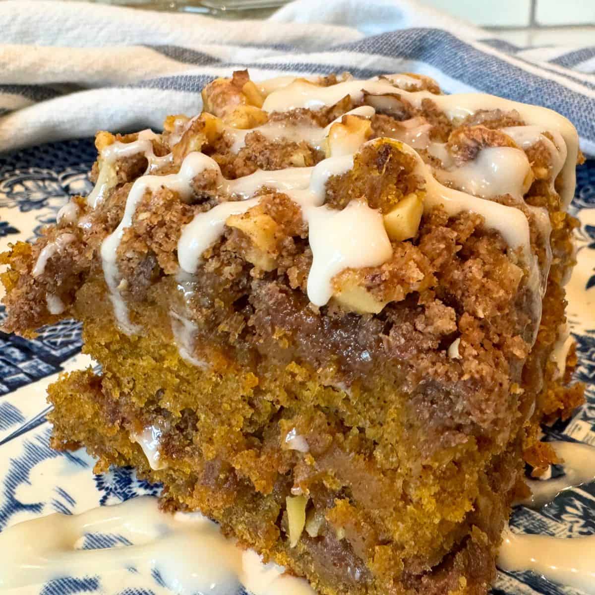 sourdough pumpkin streusel coffeecake with maple glaze on blue plate