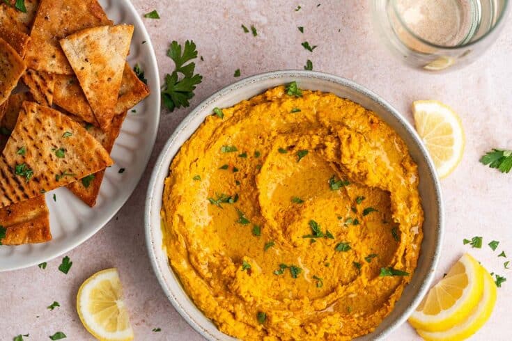 red lentil dip with pita chips appetizer with glass of white wine