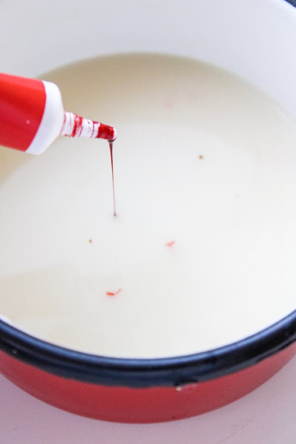 adding red food coloring to melted chocolate