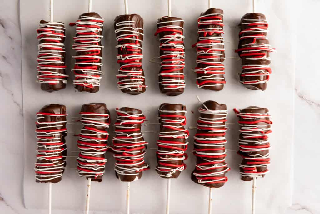 drizzle the melted red and white candy over chocolate covered marshmallows