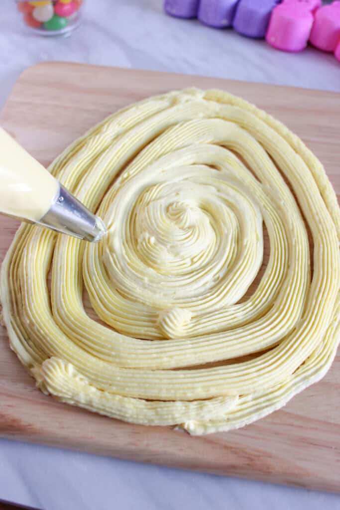 piping the frosting into an egg shape