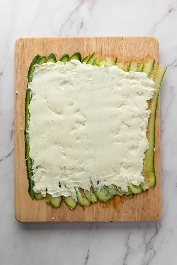 spread the cream cheese over the cucumber slices