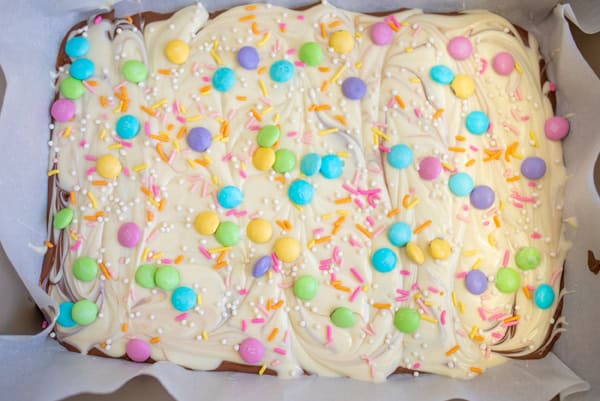 add sprinkles, m&ms, and sugar on top of the white chocolate layer