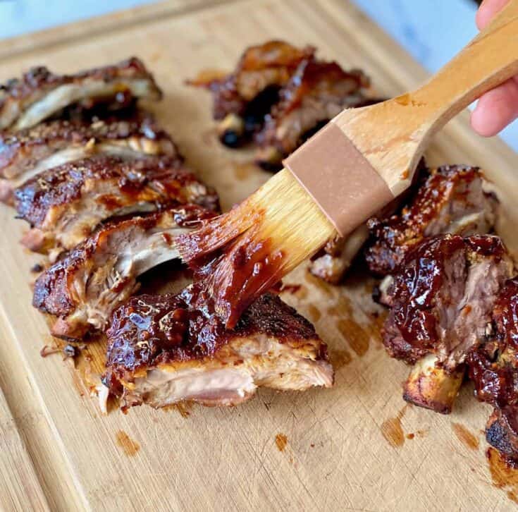 brushing sauce on cut ribs