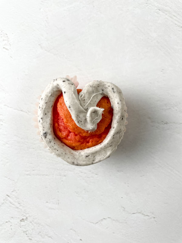 decorating the heart shaped cupcakes