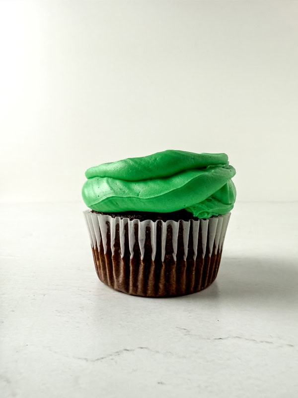 adding the green icing to the cupcakes