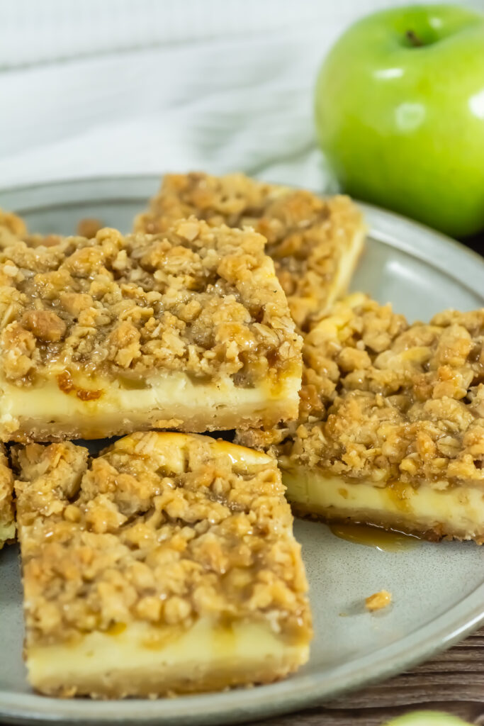 closeup of finished caramel apple cheesecake bars stacked on a plate