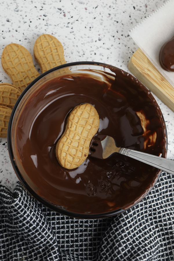place each cookie into the melted chocolate and cover both sides