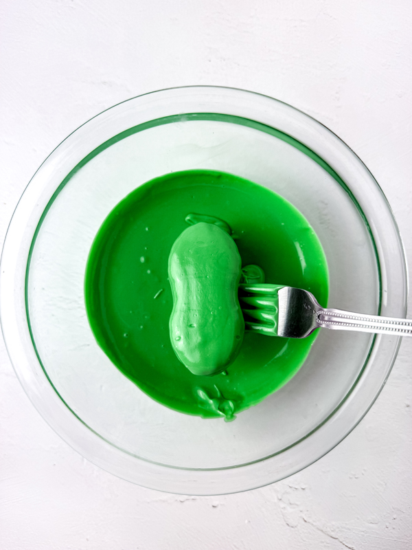 dip each nutter butter cookie into the melted green candy