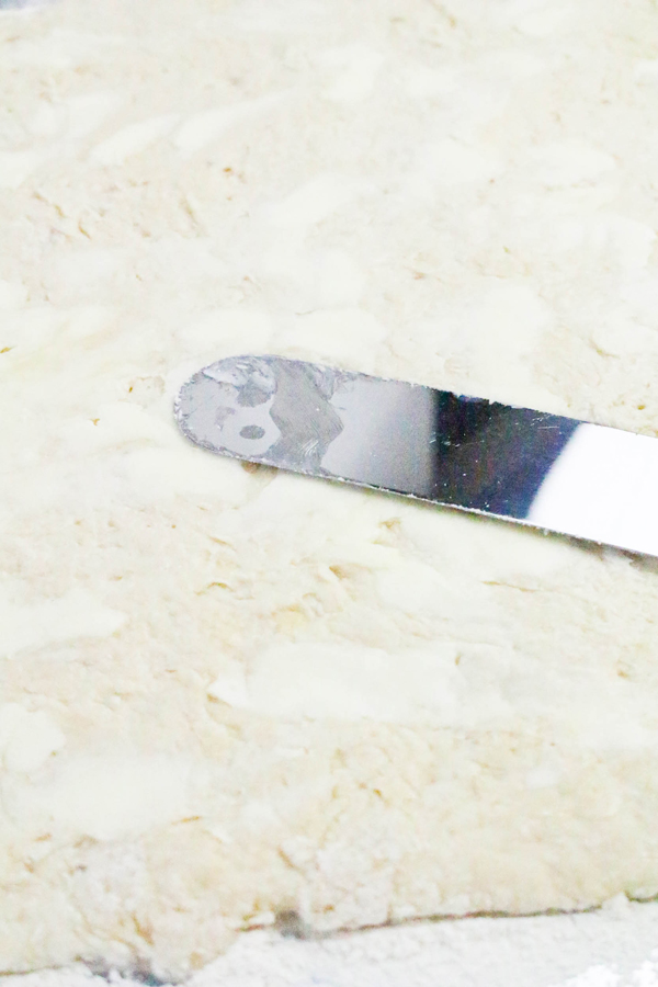 roll dough flat and use a spatula to cover it in butter