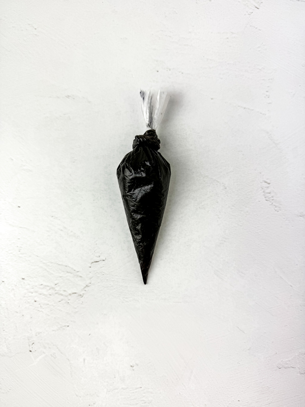 melted black candy in a piping bag