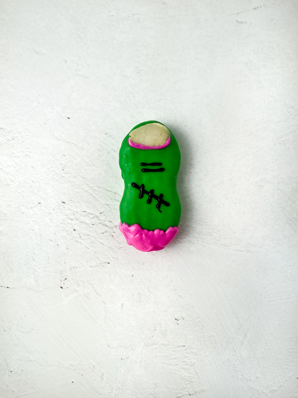pipe the pink candy around the almond slivers and at the base of the zombie fingers