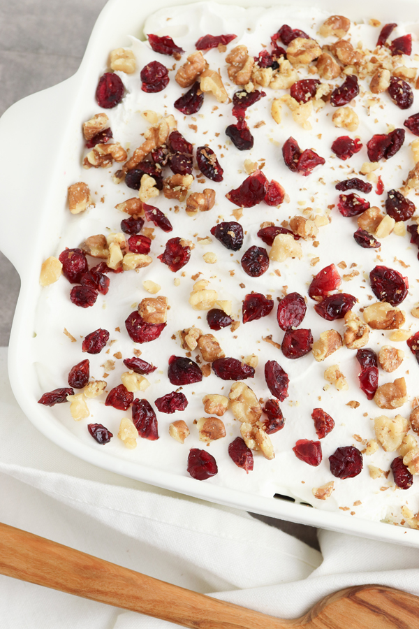 add whipped cream, walnuts, and dried cranberries to the top of the cake.