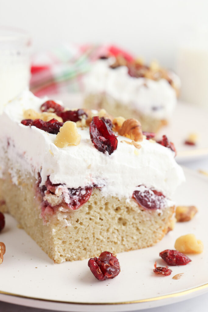 closeup of slice of cranberry sauce poke cake on a plate