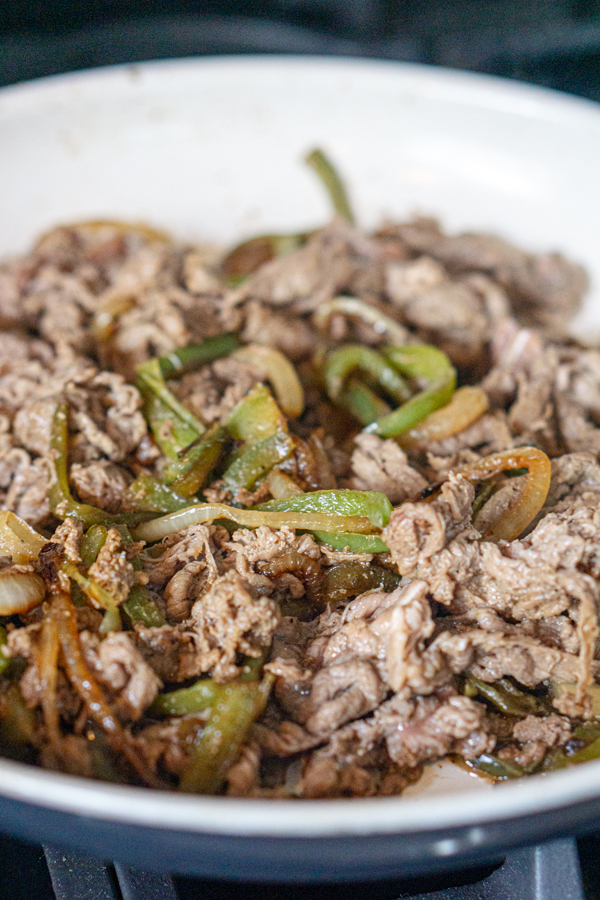 brown the shaved steak in the pan of peppers and onions