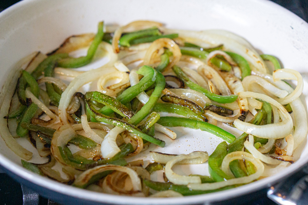 caramelize onions and peppers in a pan