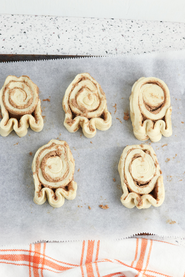 shape the cinnamon roll dough into ghost shapes
