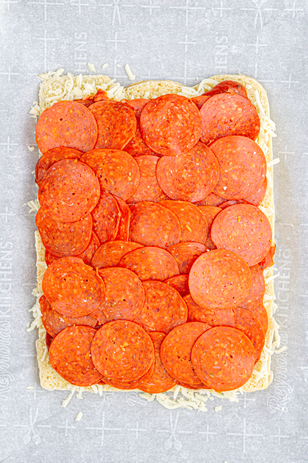 add pepperoni on top of pizza sauce