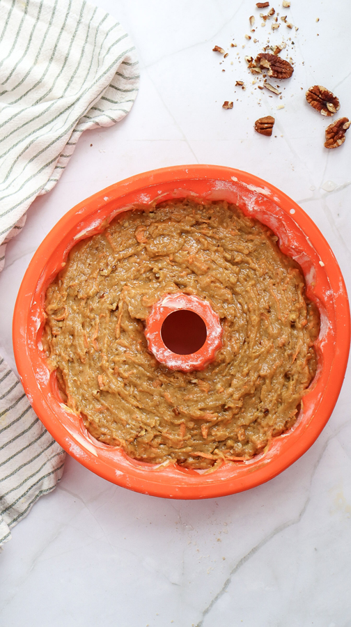 pour carrot cake batter into bundt cake pan and smooth out the top