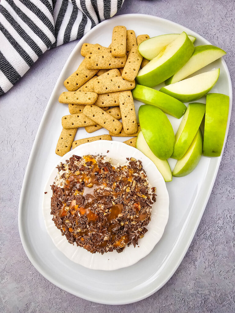 overhead shot of finished caramel apple dip on a plate with cookies and sliced apples